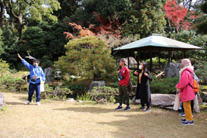 紅葉を迎えた旧広瀬邸庭園でのガイドの様子